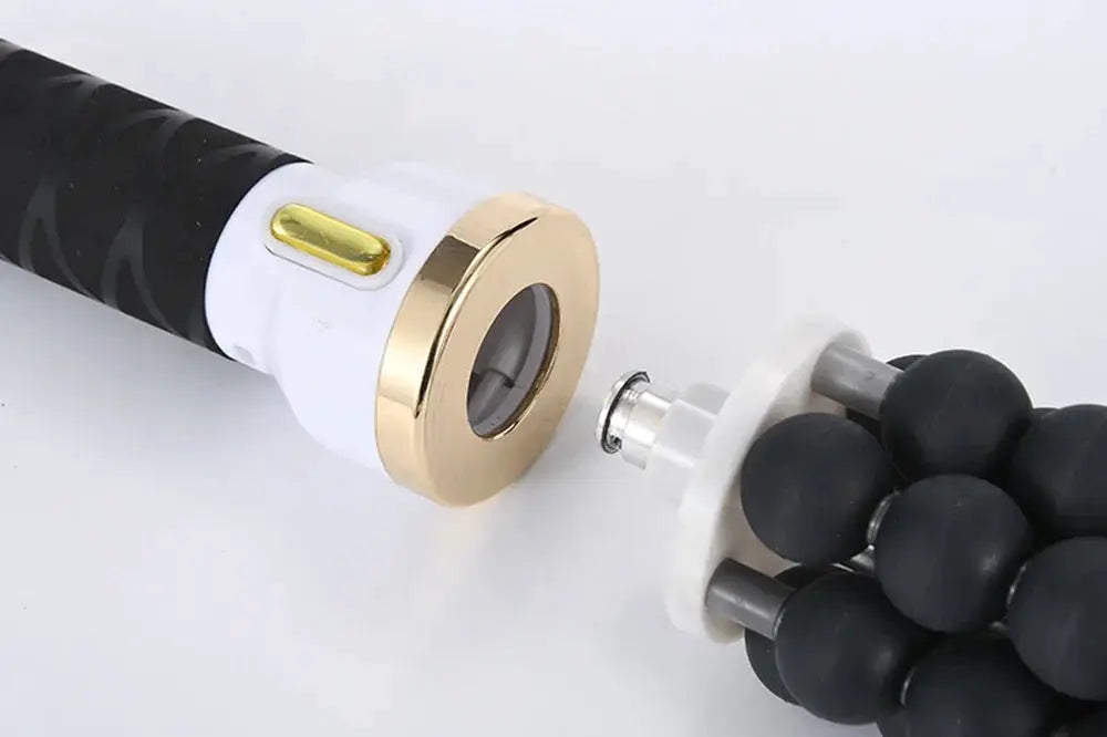 Bead massager with white body, gold ring, and black rolling head