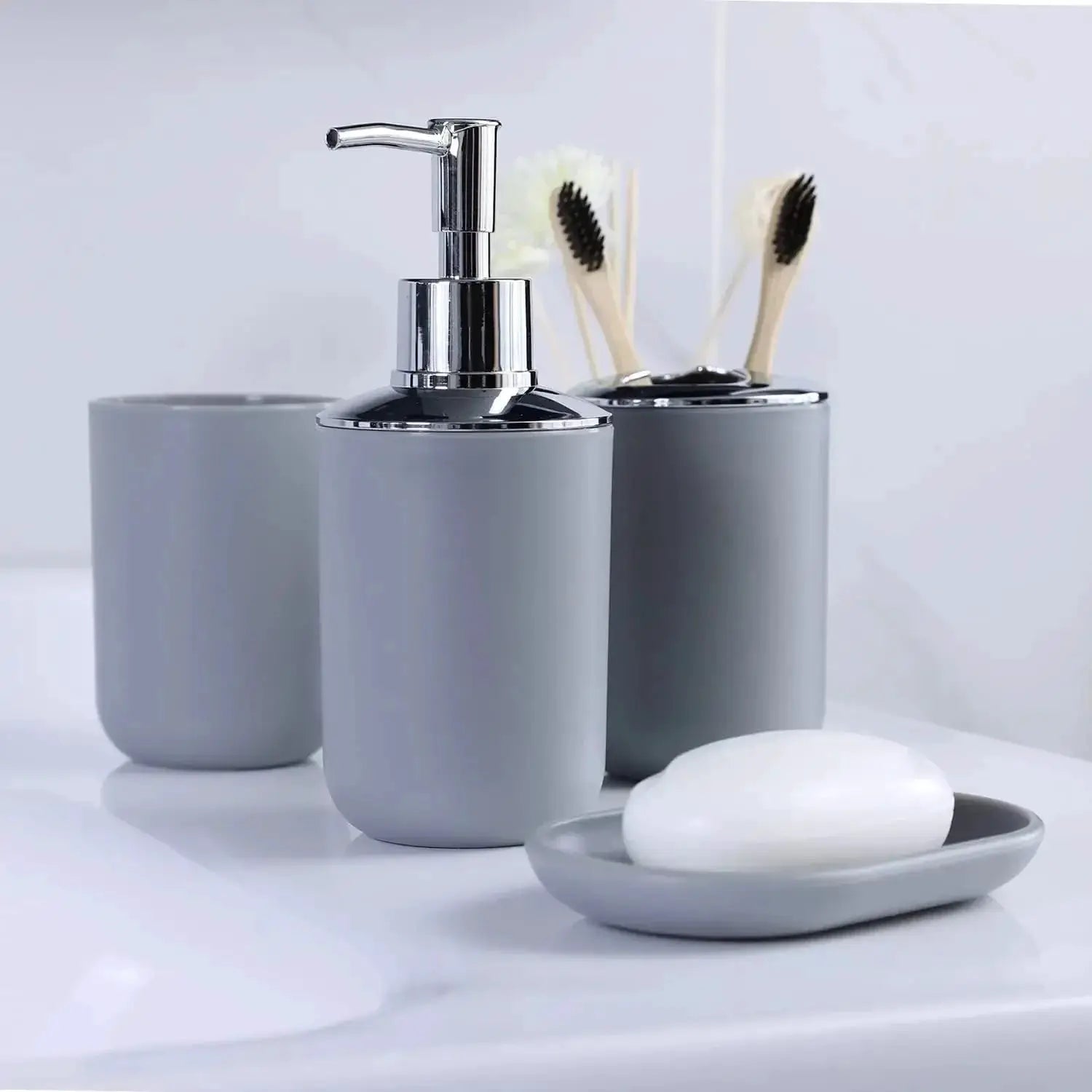 4-piece bathroom set in gray with chrome accents; includes toothbrush holder, toothbrush cup, soap dispenser, and soap dish