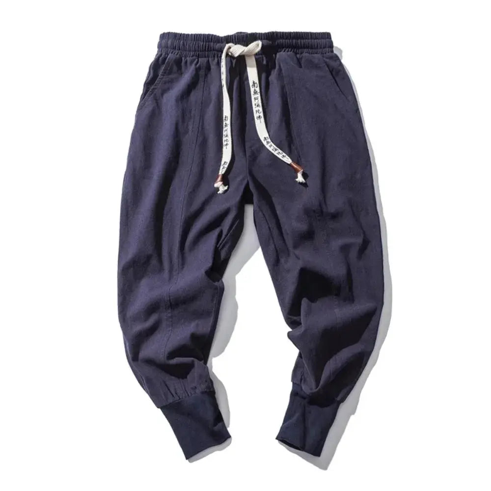 Men's cotton-linen harem pants in navy, baggy drop-crotch joggers with drawstring waist and cuffed ankles.