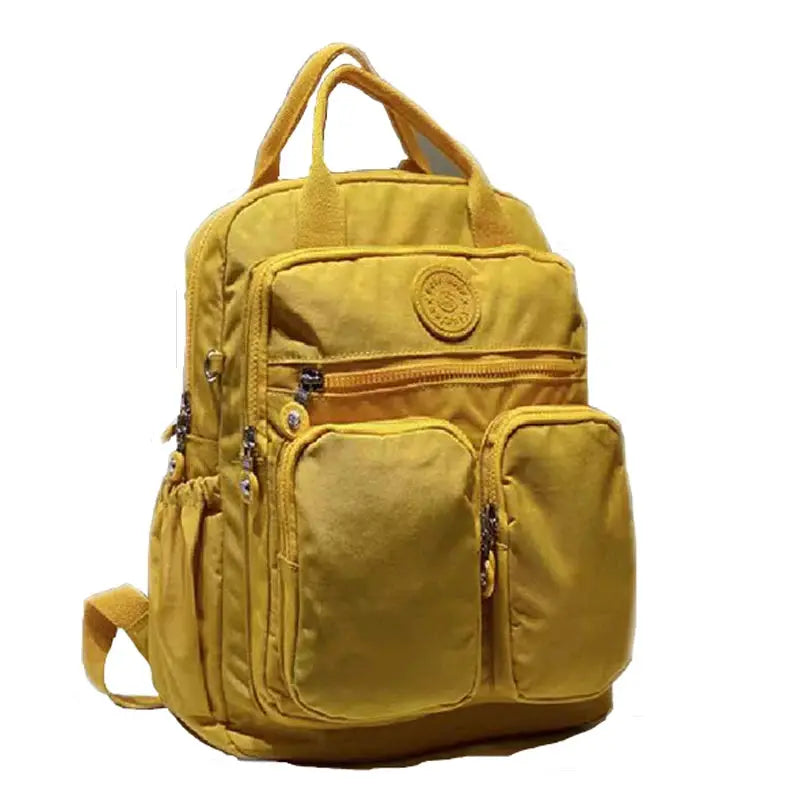 Backpack by Simples Market; yellow waterproof nylon with multiple zip pockets and top handles.
