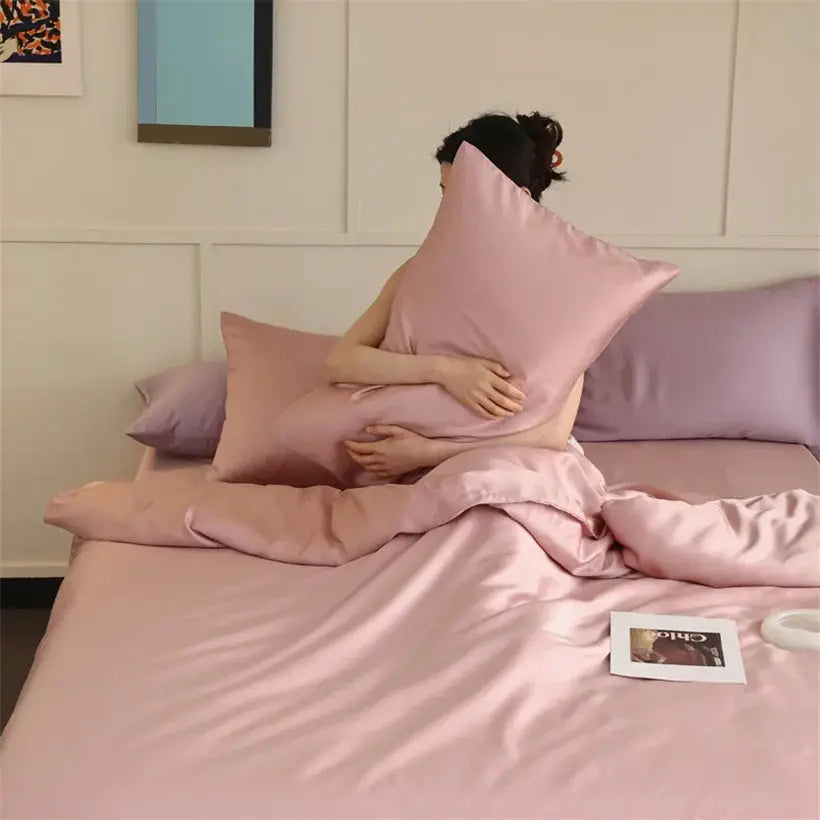 Mulberry silk bedding set in blush pink on bed with duvet cover, sheets, and pillowcases.