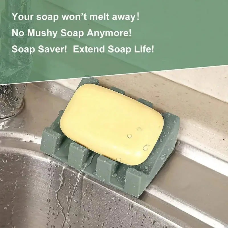Silicone soap dish in green with tilt drain rack holding yellow soap bar beside kitchen sink