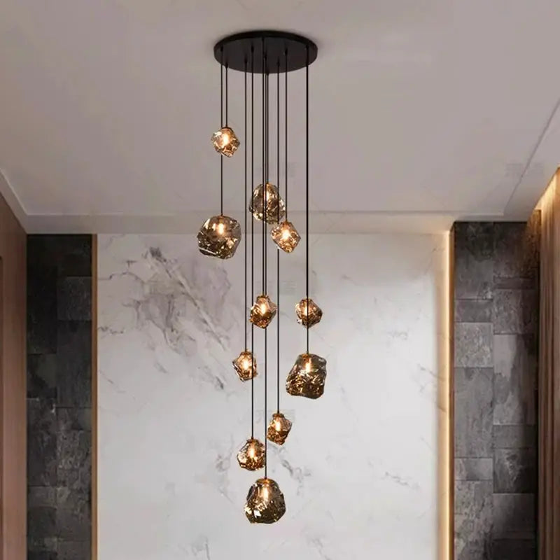 Pendant light fixture with multiple amber glass crystal pendants hanging at varying lengths from a round ceiling mount