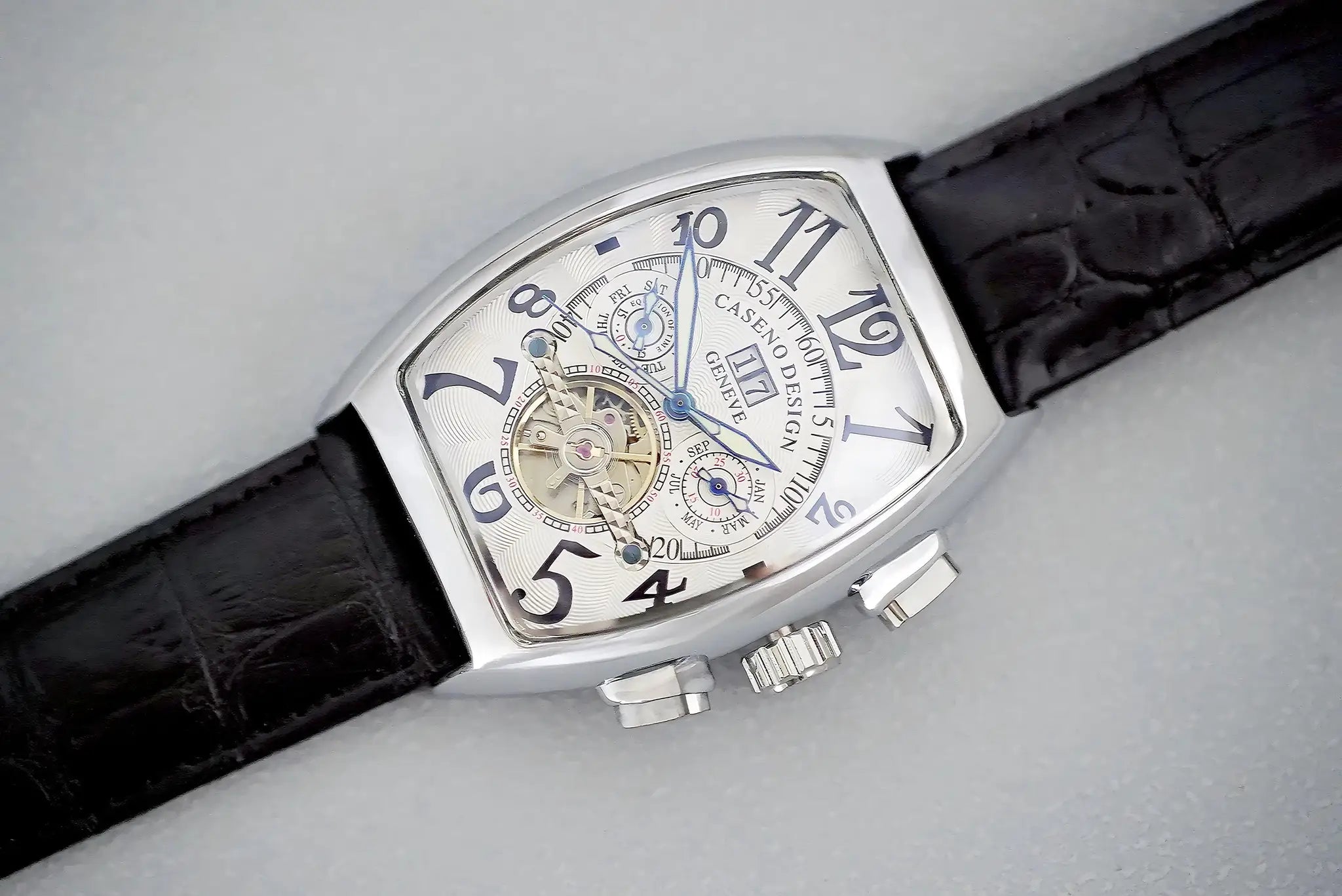Men's automatic skeleton tourbillon watch with silver tonneau case and blue hands