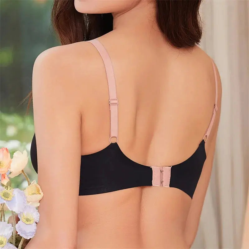 Women's seamless bra with pink adjustable straps and back clasp, black cups