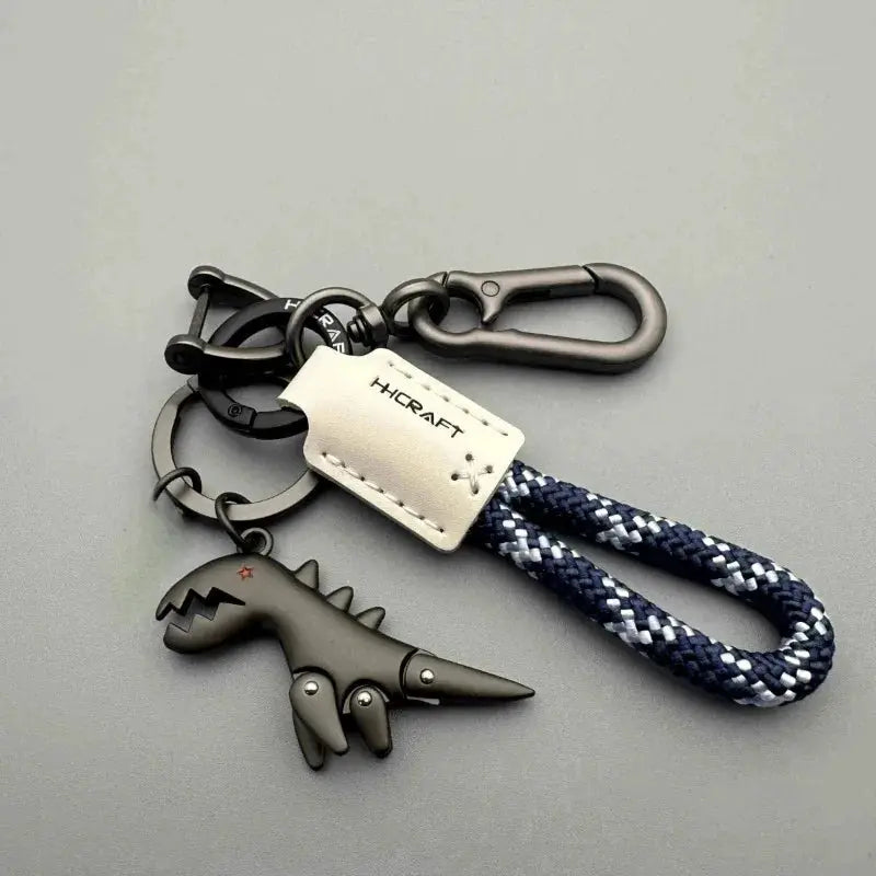 Keychain with HICRAFT leather tag, navy-white braided rope, black dinosaur charm and metal clip