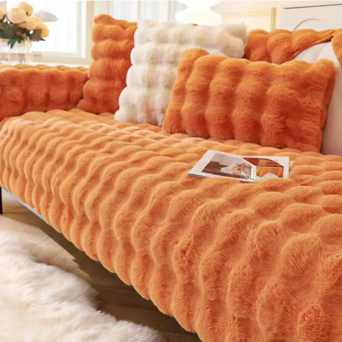 Sofa slipcover in orange faux rabbit fur with thick plush texture and matching cushions