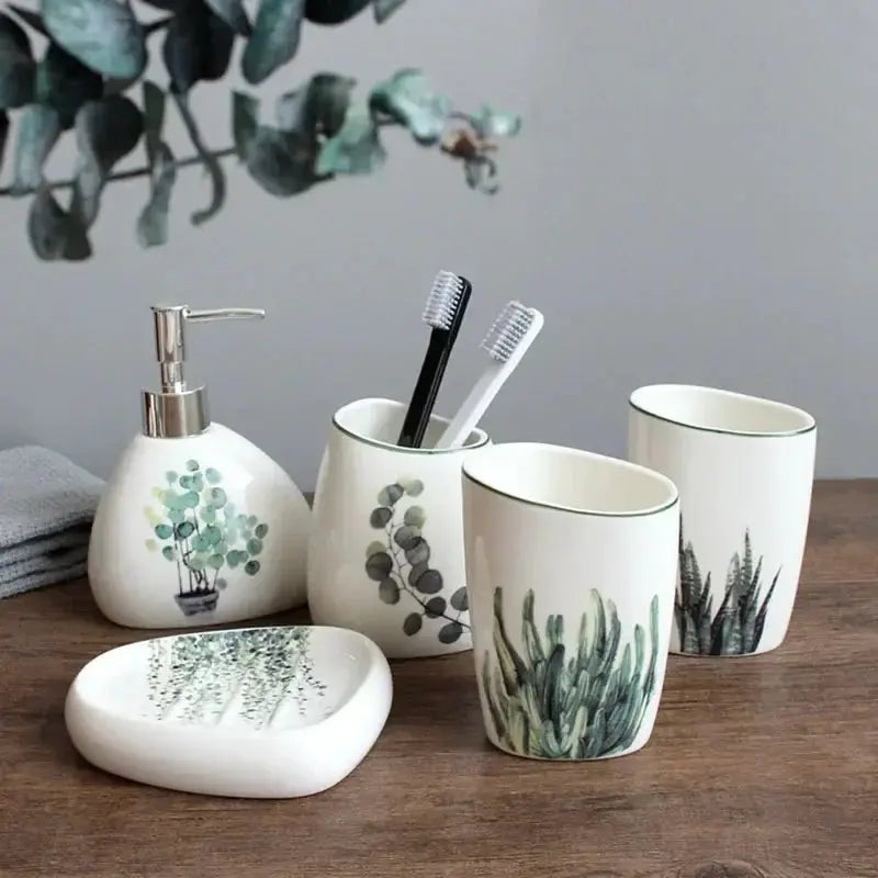 White ceramic bathroom accessory set by Simples Market with soap dispenser, toothbrush holder, two cups and tray.