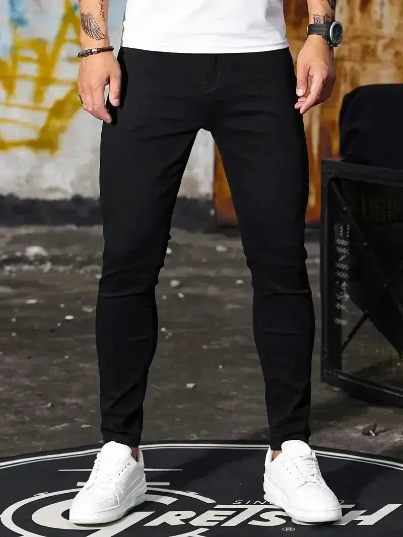 Men's slim-fit black denim jeans for casual street style, worn with white sneakers