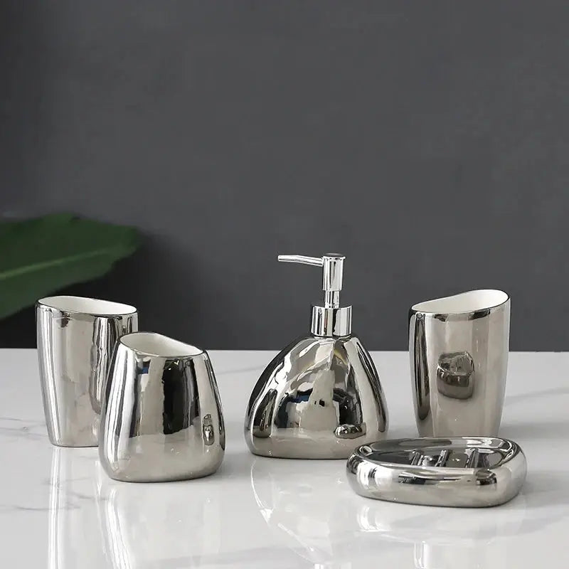 Silver bathroom accessory 4-piece set with soap dispenser, mouthwash cup, toothbrush holder, and soap dish