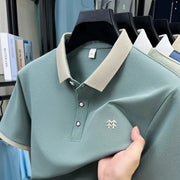 Polo shirts on hangers, five-piece display; teal polo with beige collar and small chest logo.