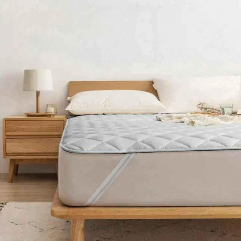 Ultrasonic mattress protector cover pad by Simples Market, washable gray quilted cover with elastic band on bed.