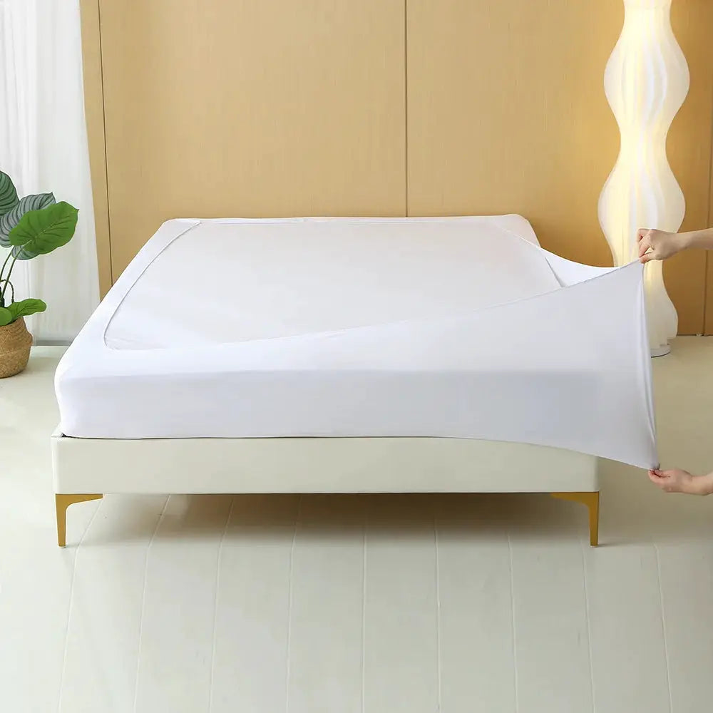 Stretchable white bed skirt on a neatly made bed in a minimalist bedroom.