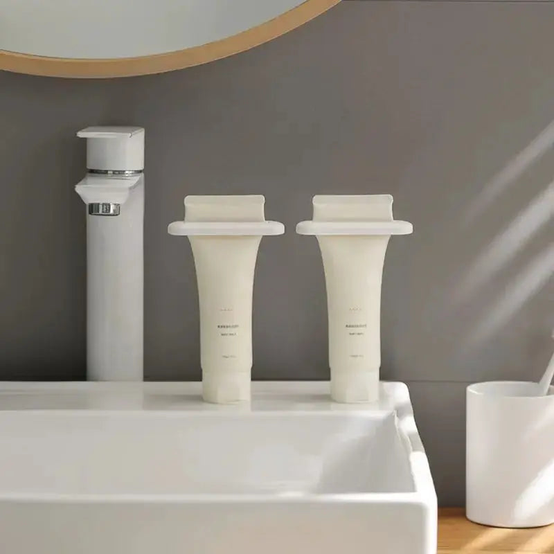 Toothpaste Squeezer set of two, white plastic, on bathroom sink.