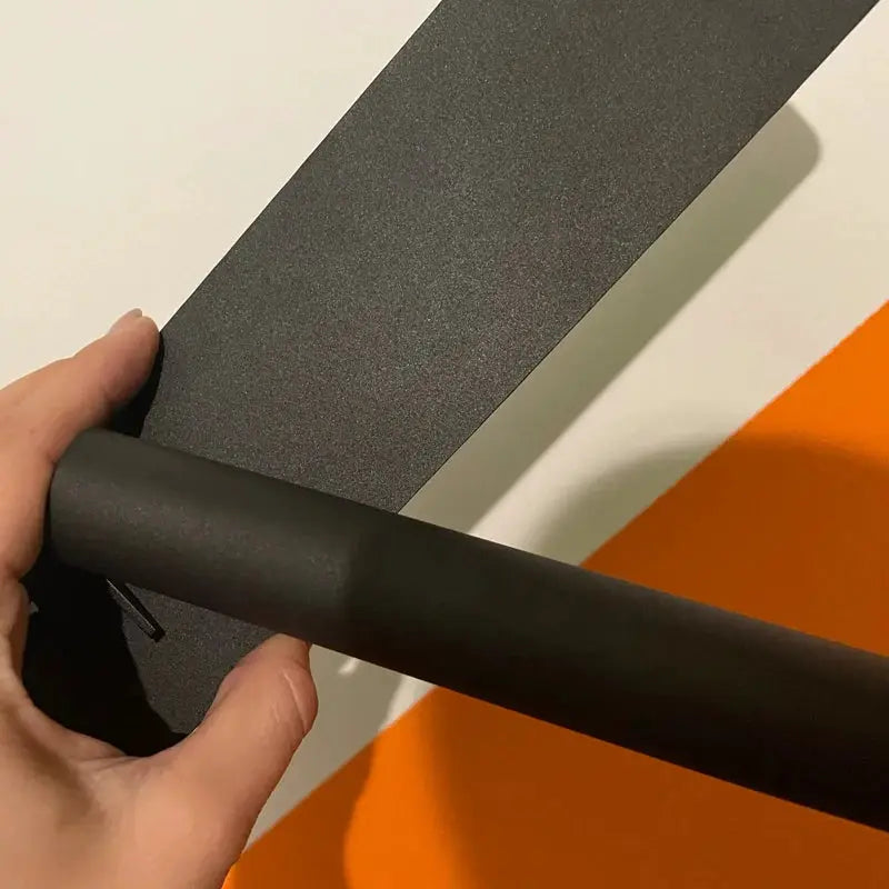 LED wall reading lamp by Simples Market, black minimalist cylindrical arm for bedside and bedroom use.