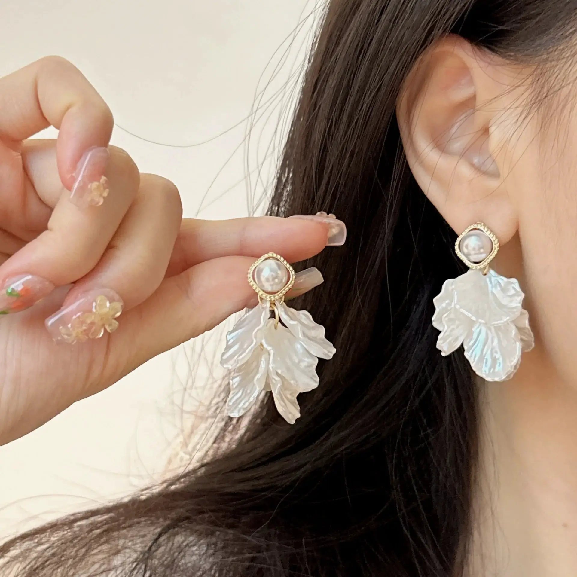 Pearl flower pendant earrings by Simples Market; glossy shell petals with gold trim, pair