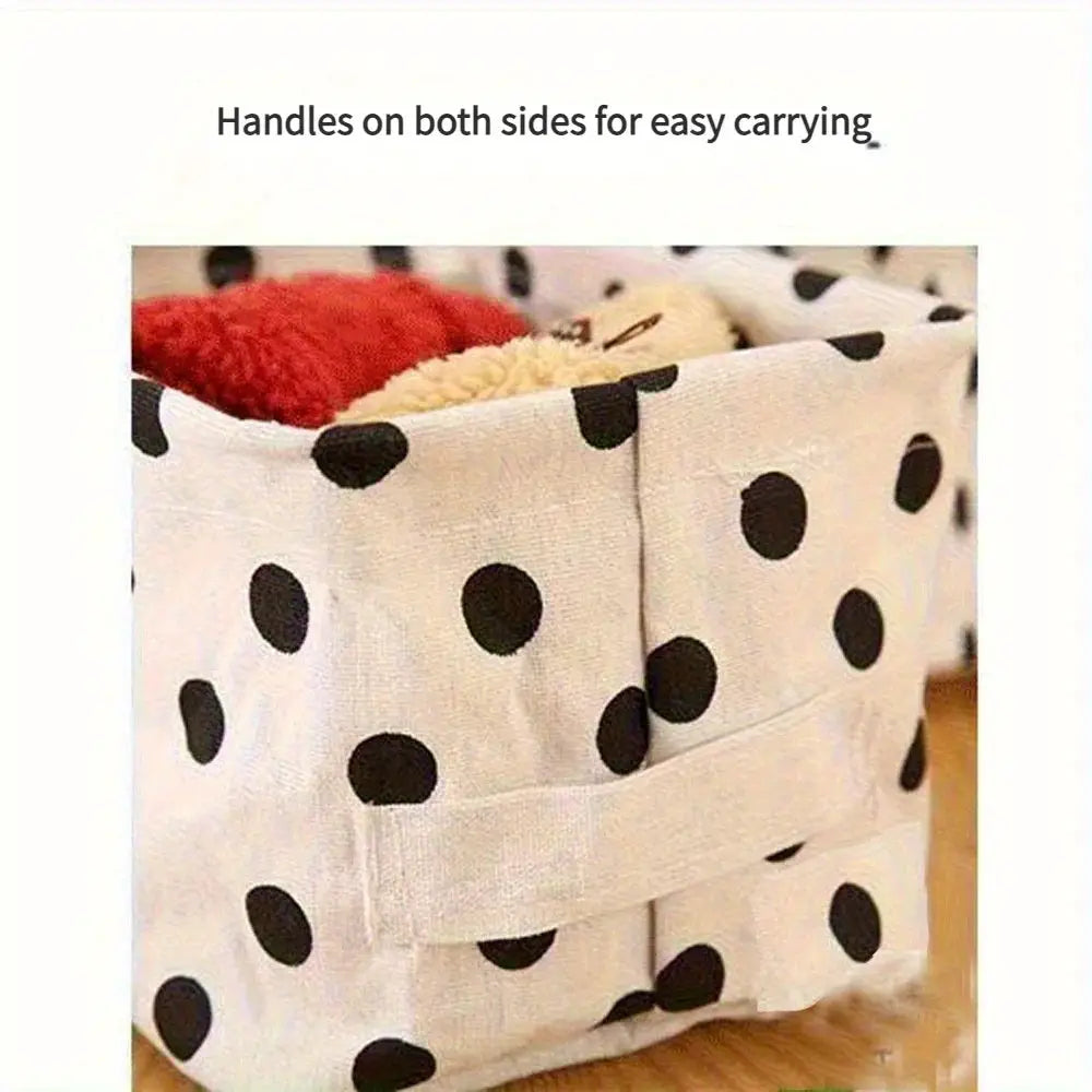 Small foldable canvas storage basket with handles; white fabric with black polka dots.
