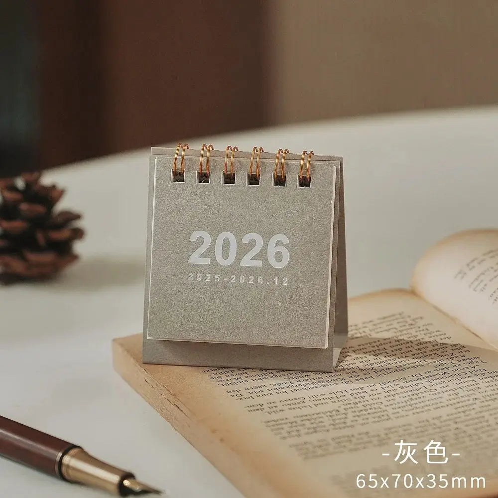 Simples Market 2026 mini desk calendar with copper coil, gray cover, 65x70x35mm