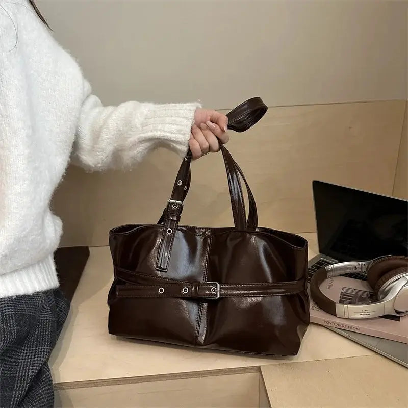 Dark brown soft leather belt-buckle handbag with top handles; casual women's shoulder bag.