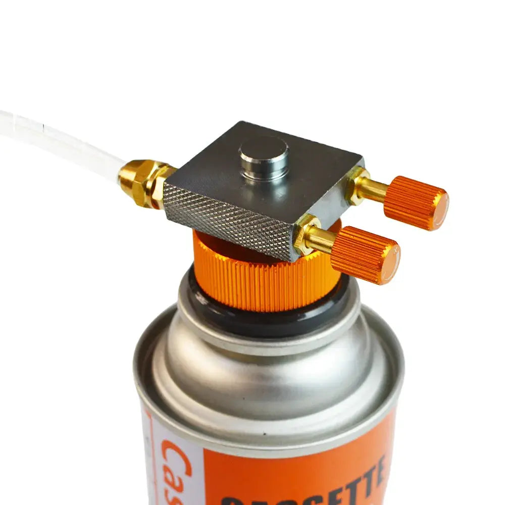Camping gas refill adapter with two orange knurled knobs and brass fittings on a small canister