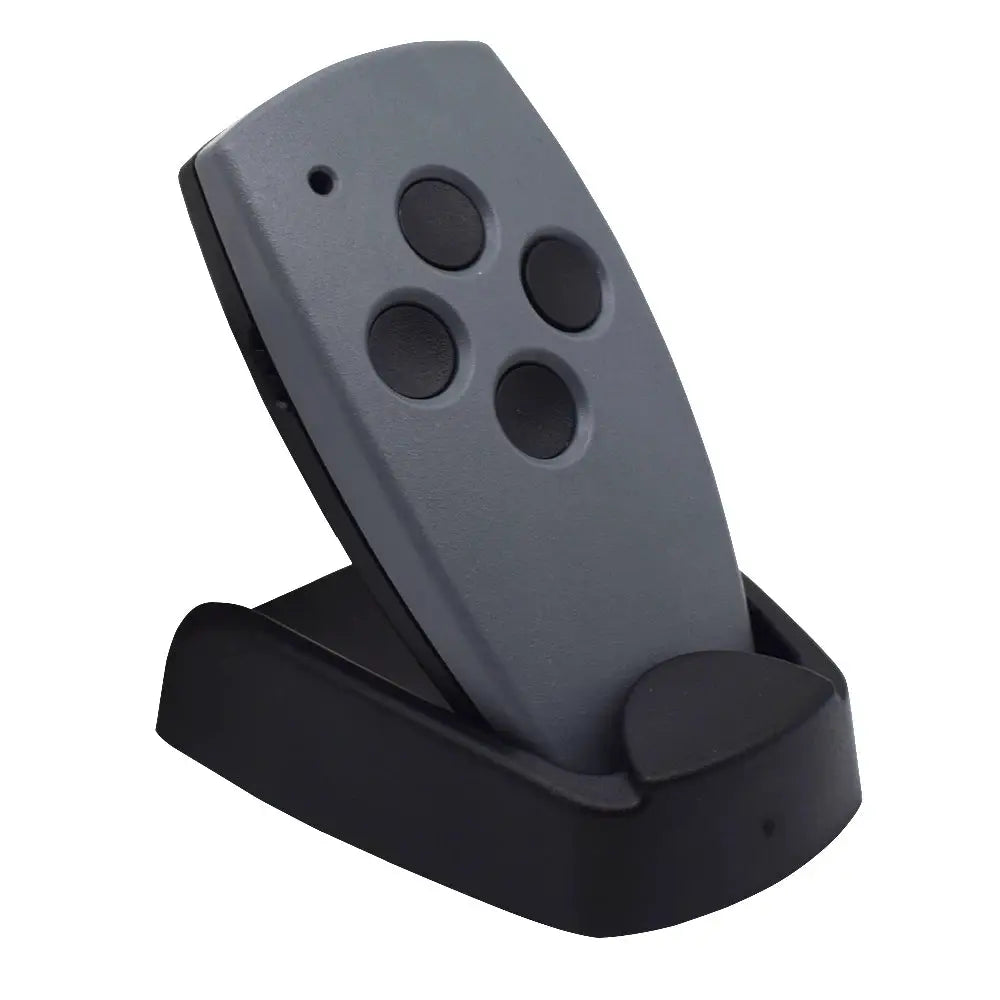 Garage door remote with four black buttons in a grey housing resting in a black charging cradle