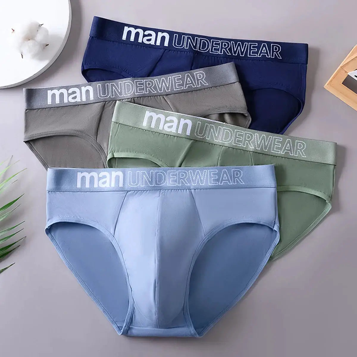 4-pack men's briefs underwear in blue, gray, sage green and light blue with waistband reading Man Underwear