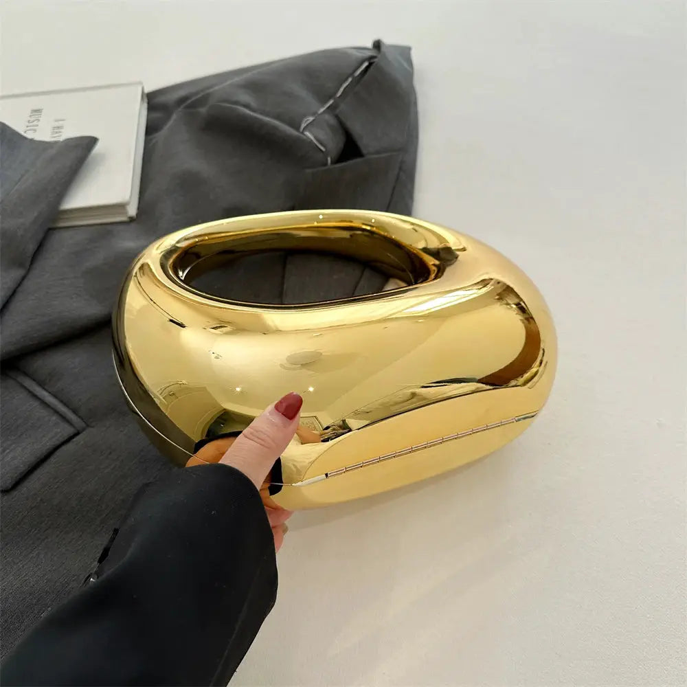 Gold round clutch handbag with a chunky circular handle; metallic PVC evening purse