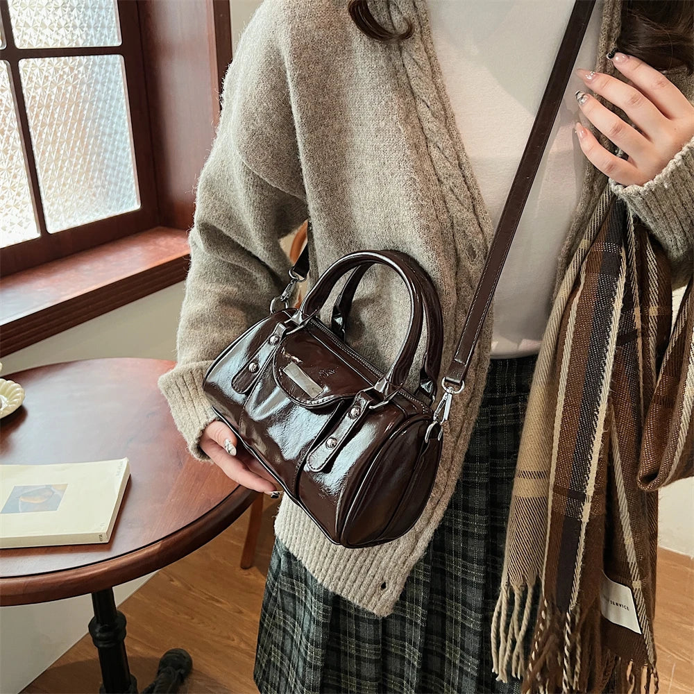 Mini burgundy top-handle bag in glossy PU leather with dual top handles and a crossbody strap for women
