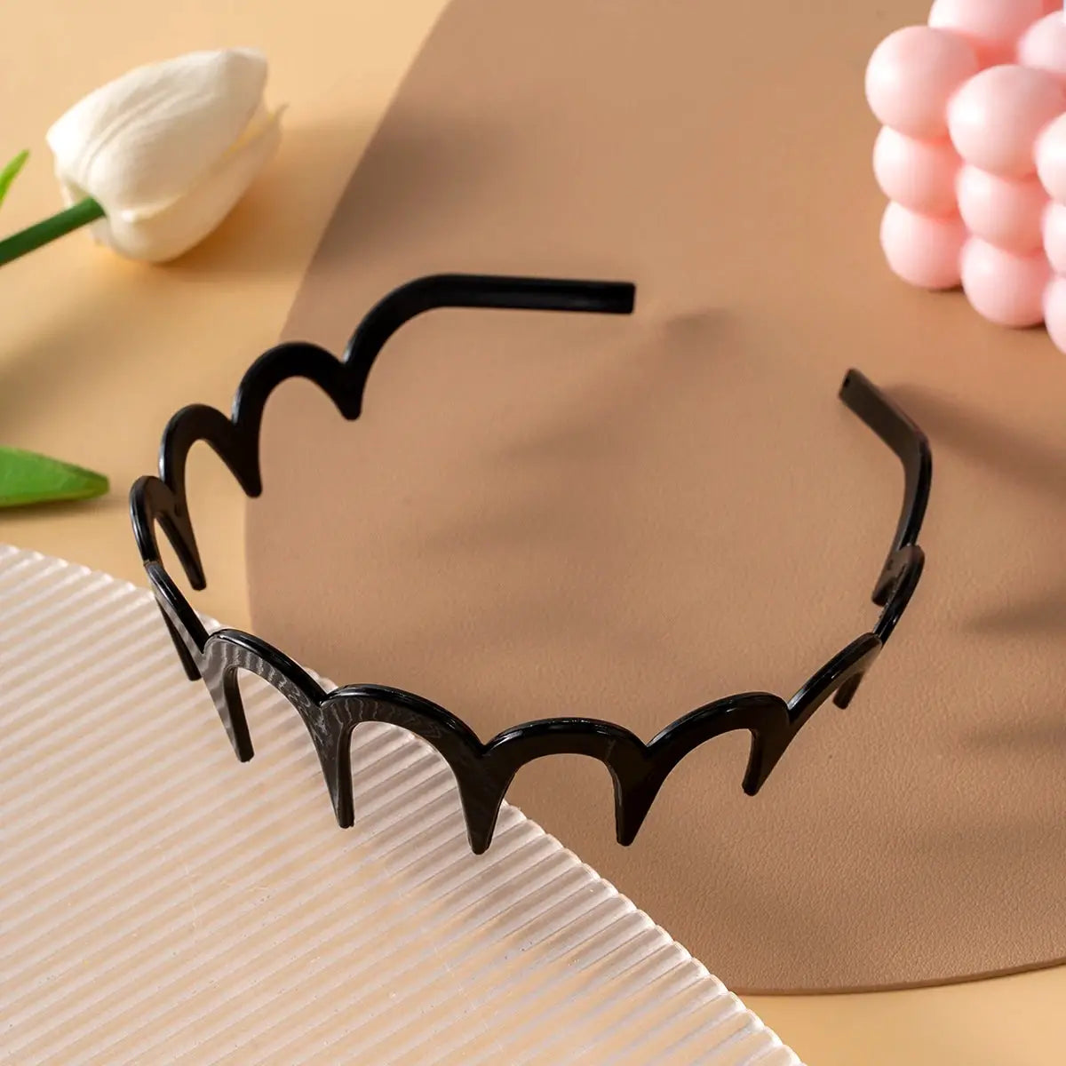 Black plastic U-shaped hairband with scalloped edge and fixed teeth for non-slip grip