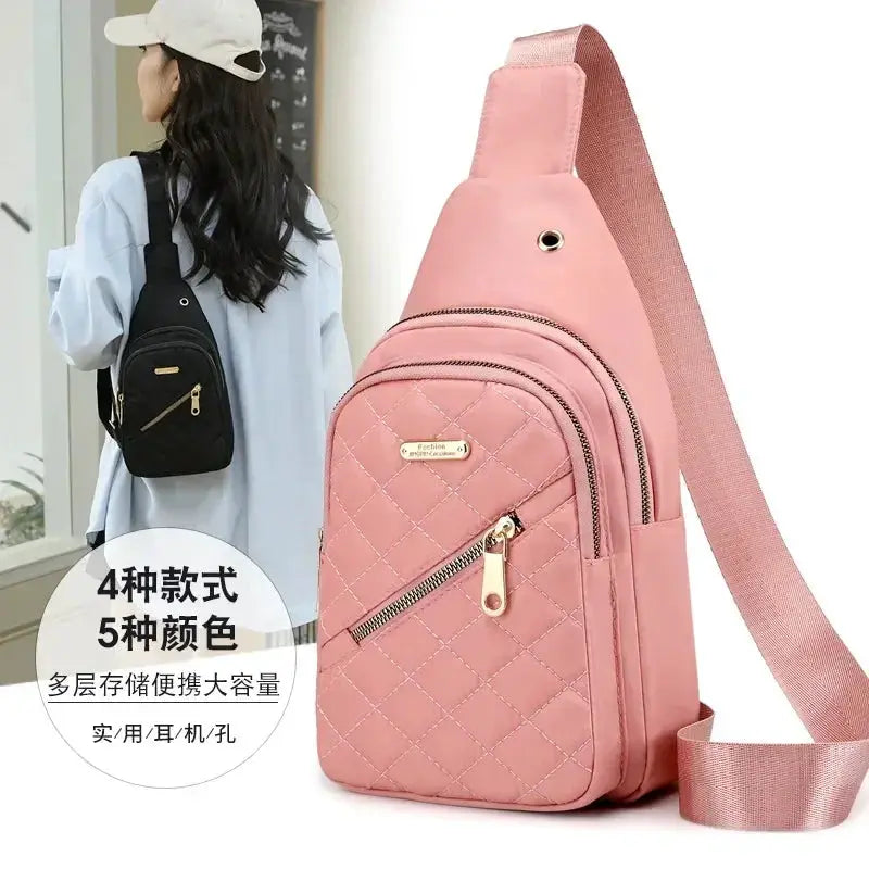 Pink quilted crossbody bag with front zipper pocket and gold hardware, adjustable strap