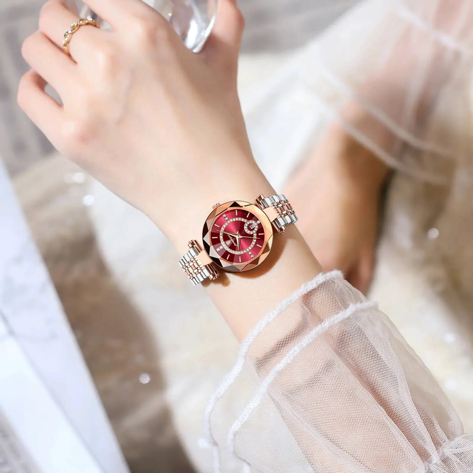 Womens rose-gold stainless steel quartz wristwatch with red dial, crystal bezel, and two-tone bracelet.