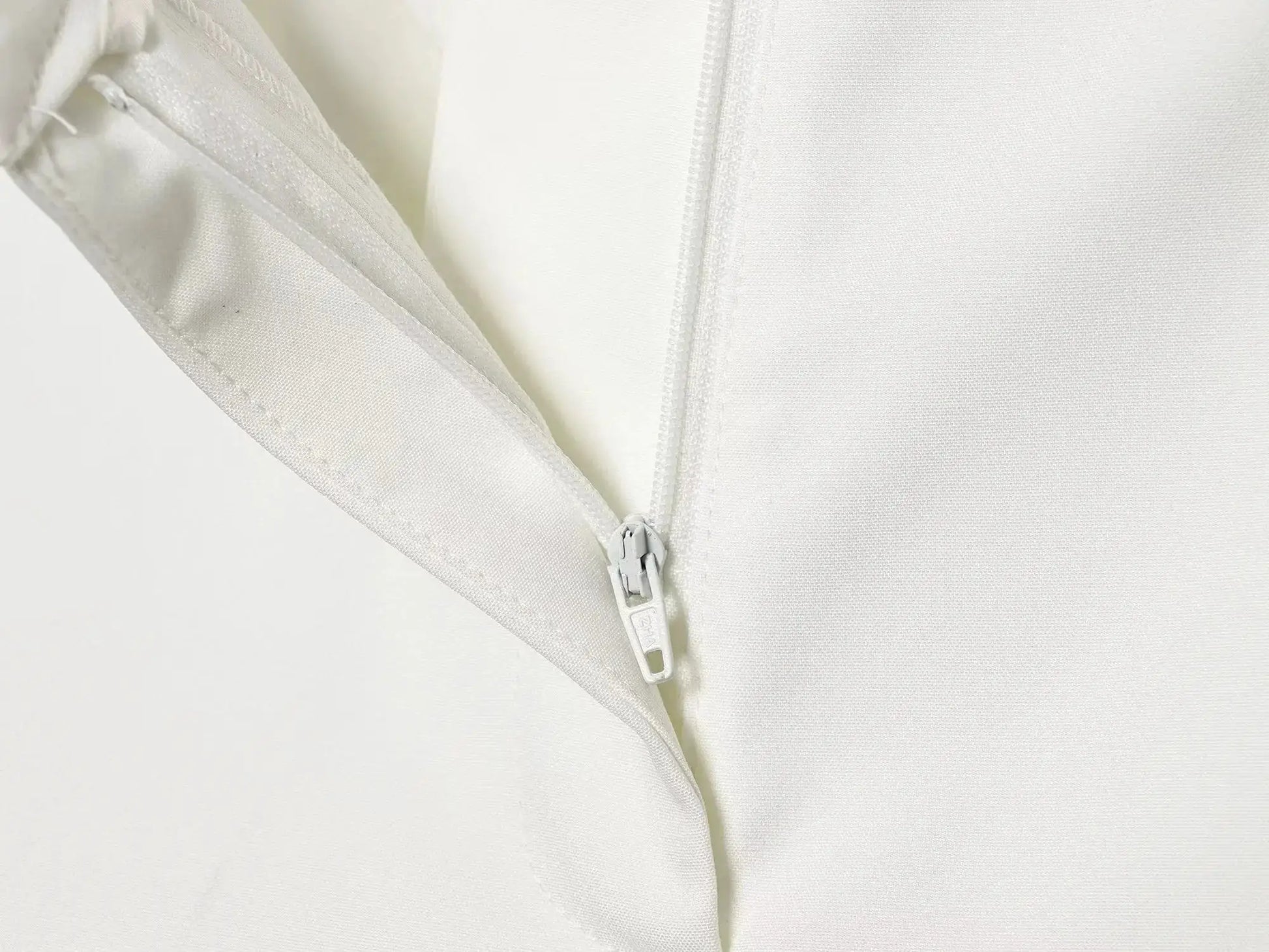 Blazer in white with zipper front detail, close-up fabric texture
