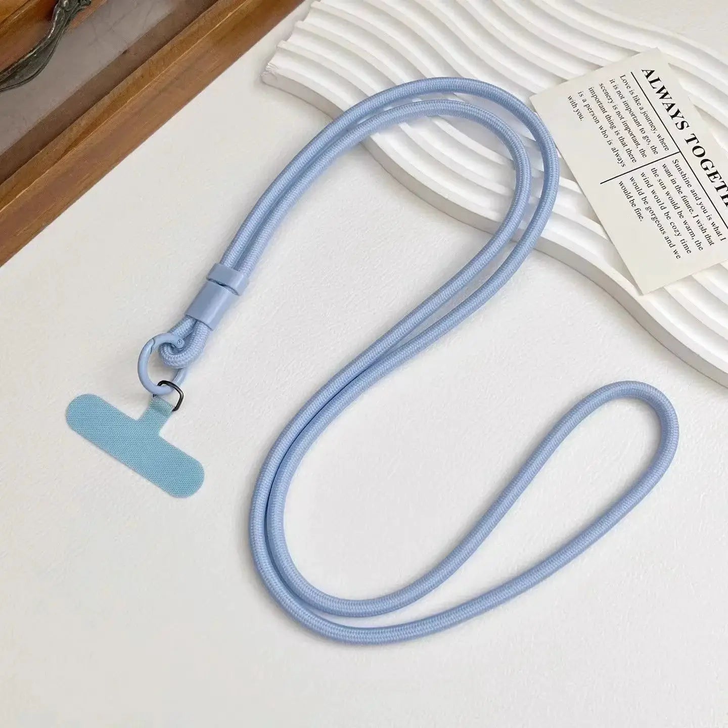 Light blue mobile phone lanyard with dual-strap rope, adjustable slider and metal ring attachment