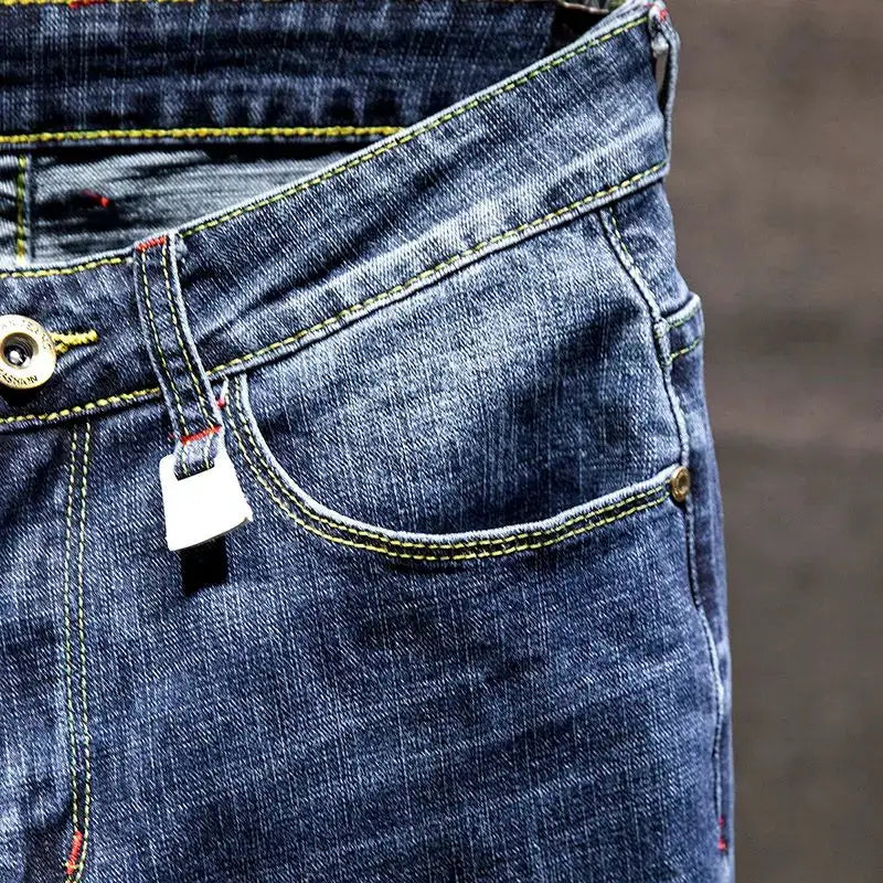 Men's blue denim jeans with yellow contrast stitching and front pocket detail