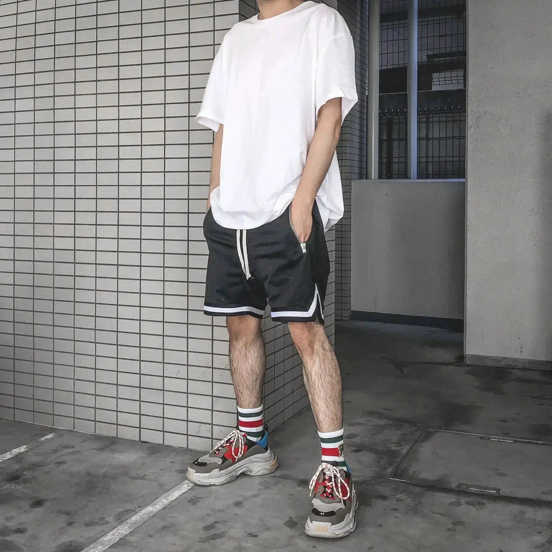 Men's black mesh quick-dry basketball shorts with white piping and drawstring