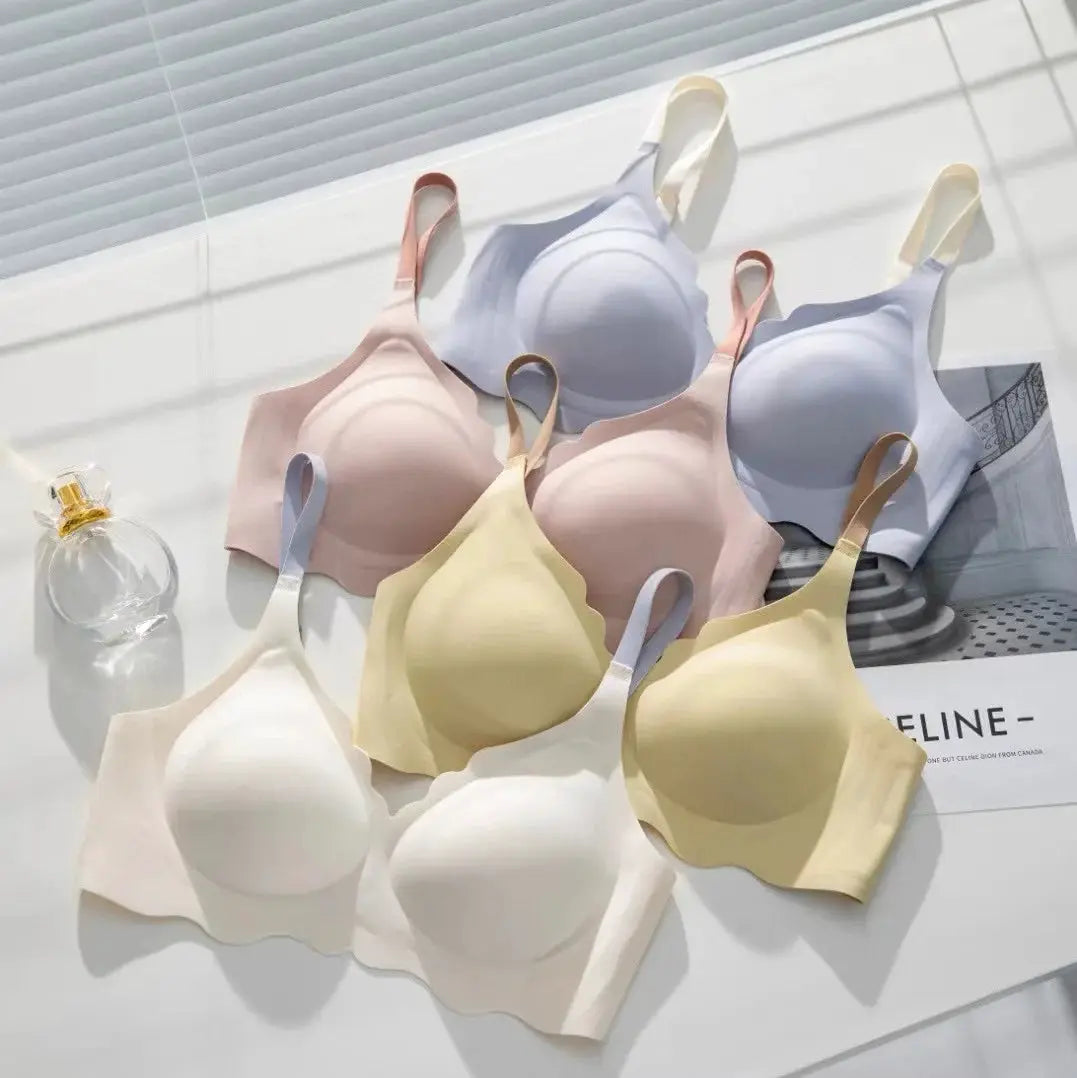 No Trace Top wireless bras in pastel colors; several seamless cups with wide straps laid on a white surface