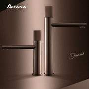 Brass-black bathroom faucet set with two tall cylindrical taps by Simples Market; Aitana logo visible.