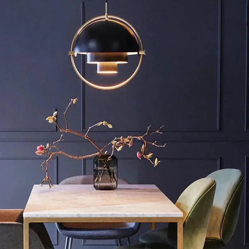 Pendant light with iron-gold chrome finish, black dome and circular ring over dining table