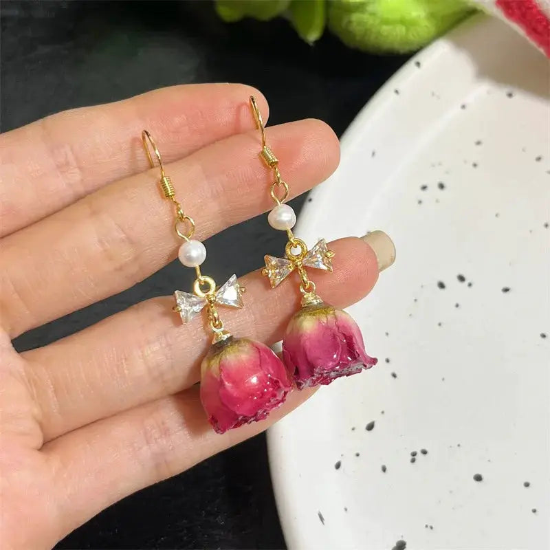 Rose earrings by Simples Market; epoxy resin drops with pearl beads and crystal bow accents