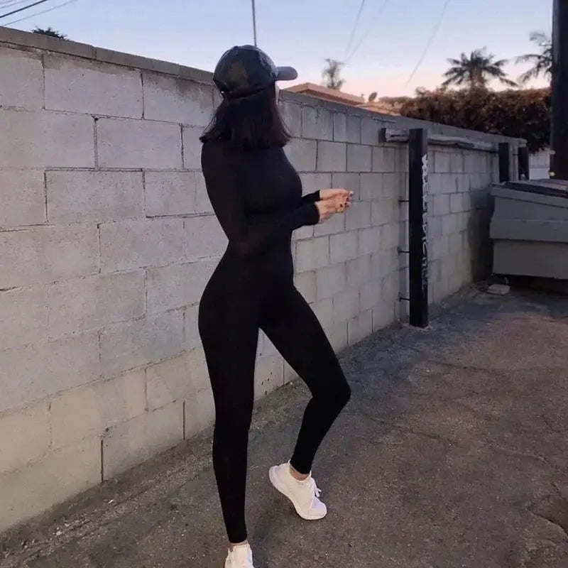 Women's black long-sleeve athletic jumpsuit, full-body slim-fit fitness outfit