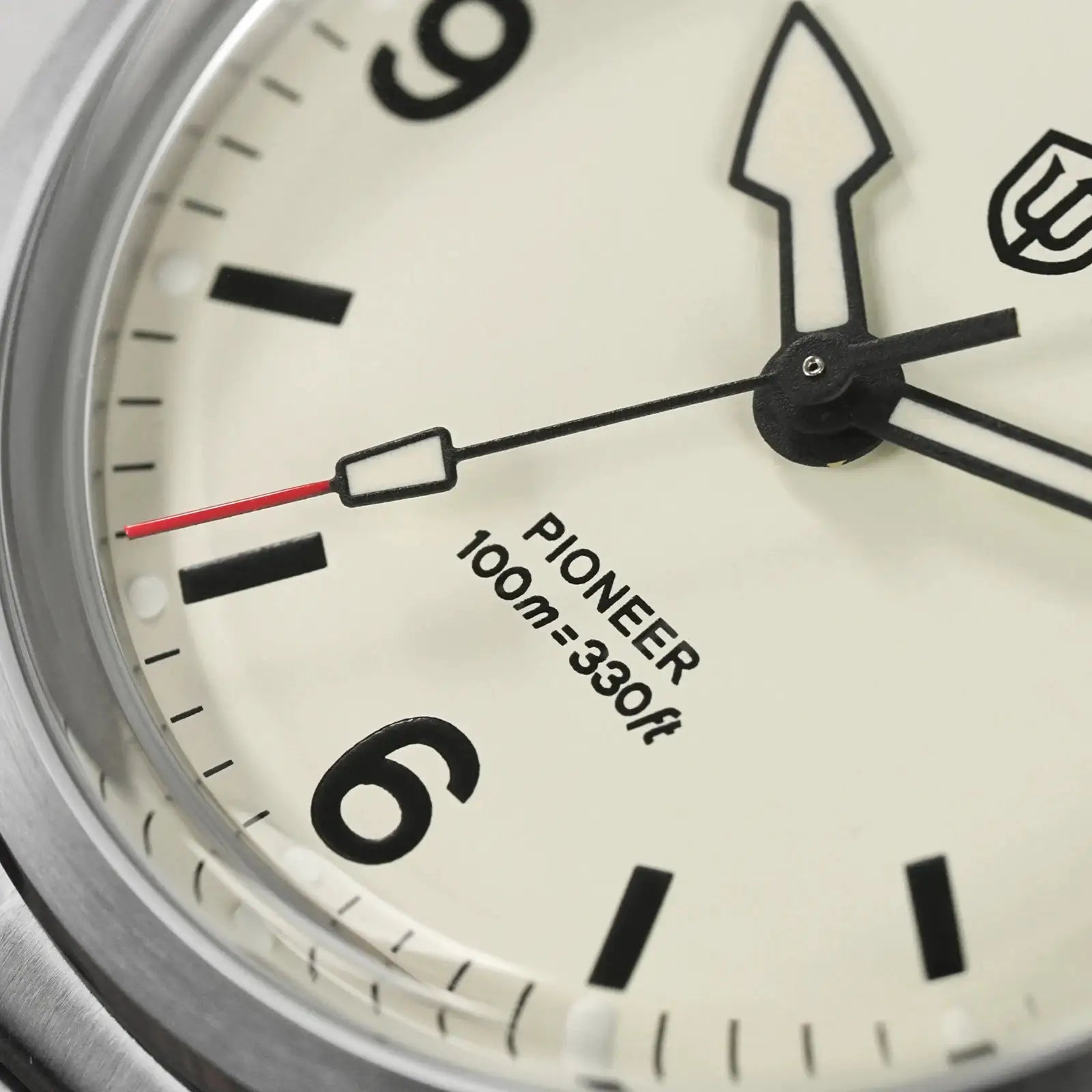 Watch with white dial, black hands and red second hand, stainless steel bezel, Pioneer 100m=330ft text visible.