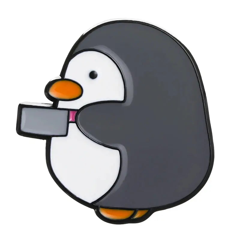 Cartoon penguin enamel pin brooch by Simples Market; gray body with white belly, orange beak, holding a gray rectangle