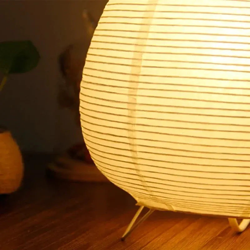 Japanese lantern LED table lamp by Simples Market; white rice paper shade with tripod metal legs, warm glow