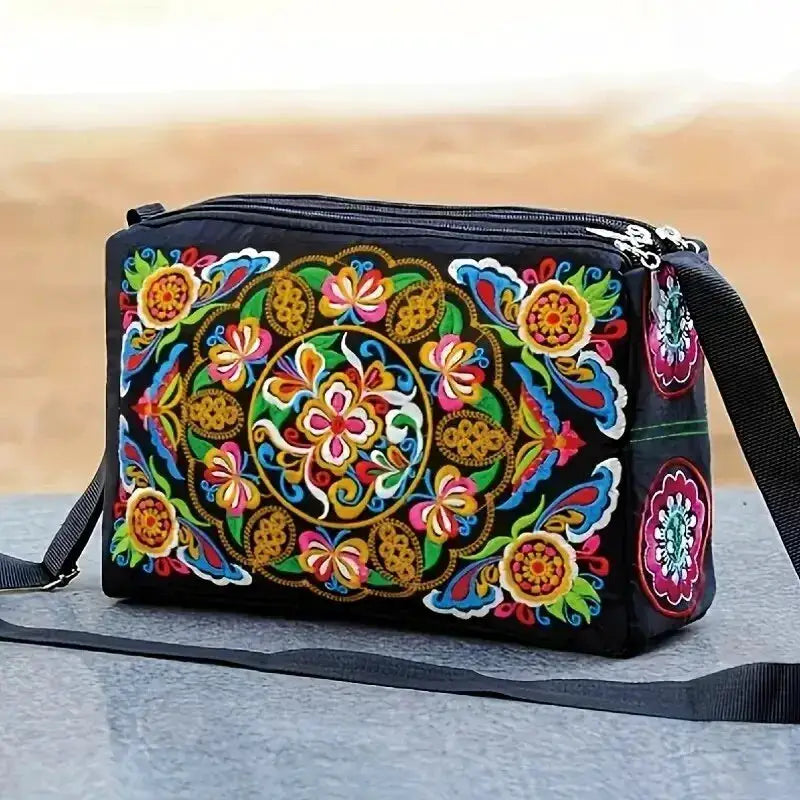 Women's embroidered floral nylon crossbody bag in black with vibrant multicolor pattern and adjustable strap.