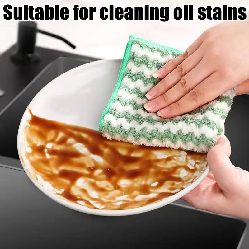 Microfiber dishcloth, green and white striped, used to wipe sauce from a plate.
