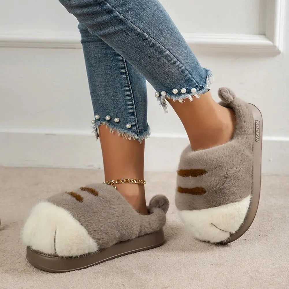 Pair of 3D cat paw plush slippers in gray with white paw pads, fluffy slip-on home slippers with anti-slip sole