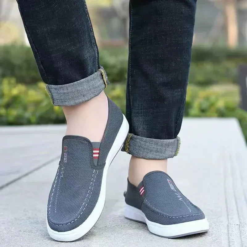 Men's canvas slip-on sneakers in gray-blue with white sole; two shoes shown