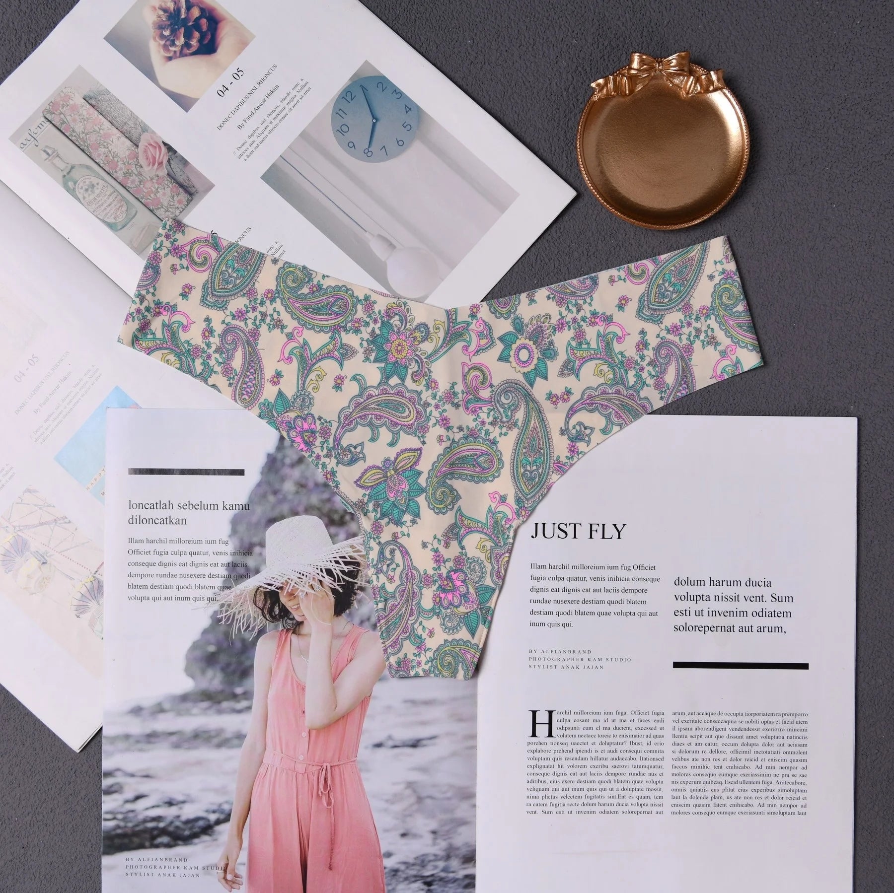 Women underwear abc01 by Simples Market displayed on a desk with colorful paisley-patterned envelope and magazines