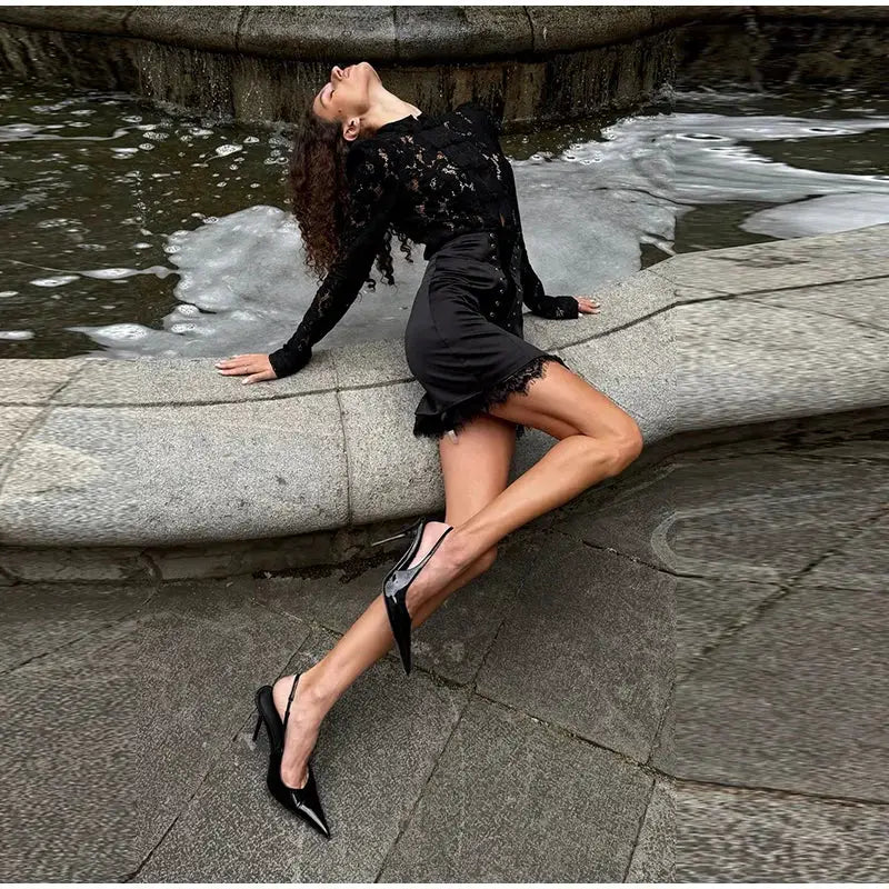 Women's black lace-trim mini skirt shown on a model wearing black heels