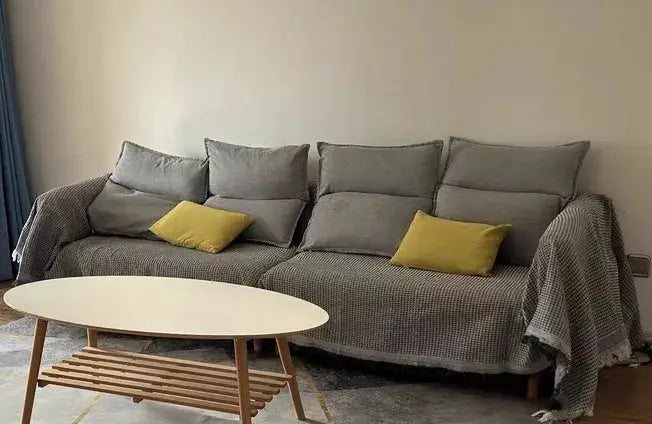 Sofa throw blanket cover in gray checkered fabric on a sofa with matching cushions and yellow accent pillows